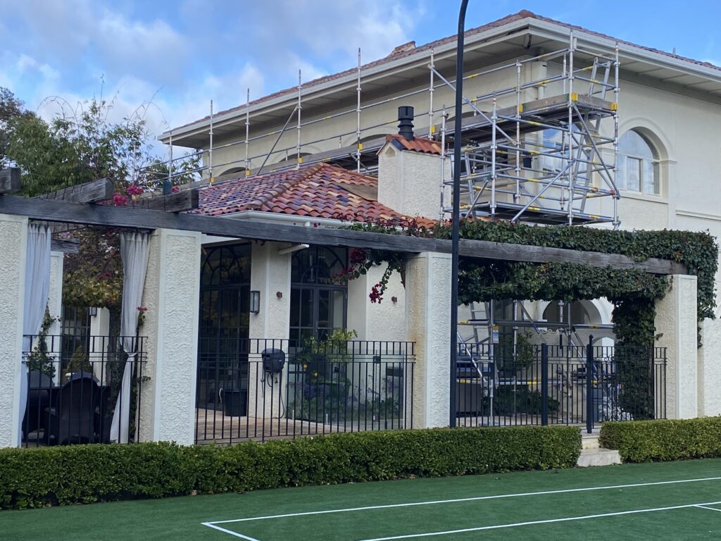 A steep-slope scaffold system is securely installed on a residential roof, allowing workers to safely access high-pitched areas to perform roofing tasks. The scaffolding provides essential protection and support, ensuring safety standards are met while minimizing the risks associated with working at heights.