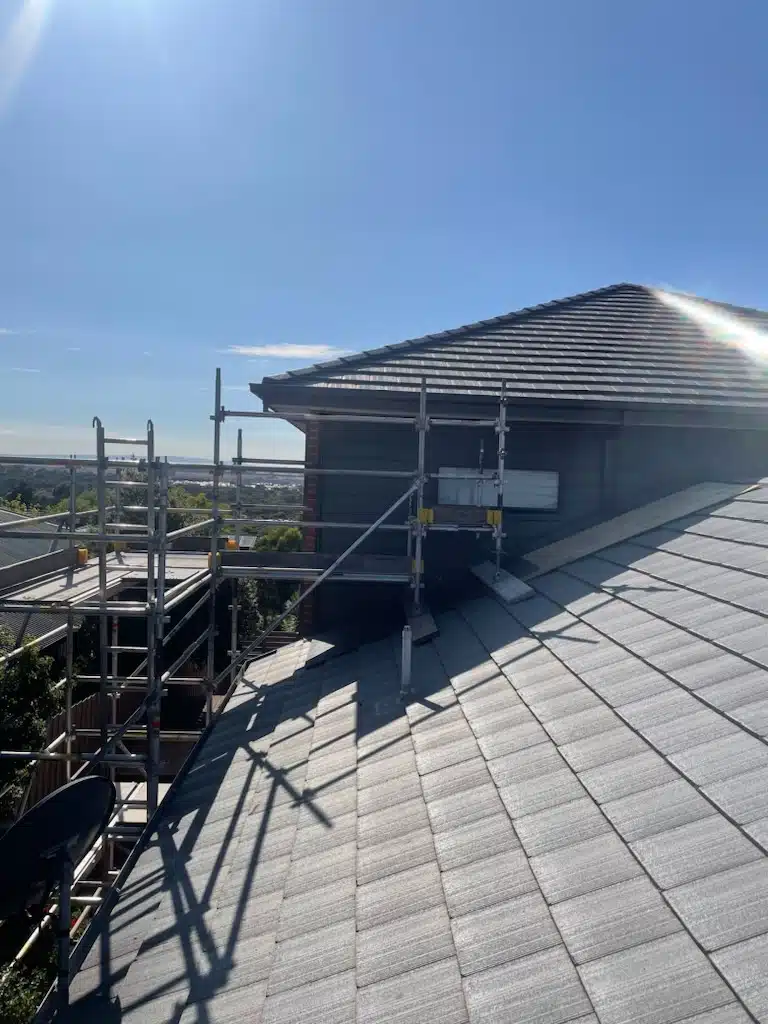A group of construction workers can safely perform tasks on a roof structure, utilizing a scaffolding system that provides fall protection. The scaffolding is designed to ensure safety standards are met while they work on the roofing project, reducing the risk of accidents at height.